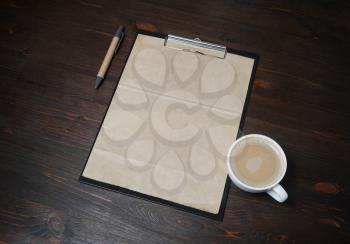 Vintage stationery set. Blank kraft paper, checklist, pen and coffee cup on wood table background.