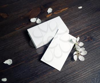 Blank business cards and flowers on wood table background. Mockup for branding identity.