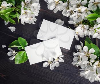 Photo of blank business cards and flowers on wood table background. Template for ID. Top view. Flat lay.