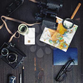 Planning vacation trip with map on vintage wood table background. Travel or vacation concept. Top view. Flat lay.