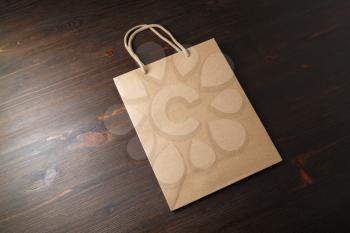 Blank vintage paper bag on wood table background. Recyclable package. Template ready for your design.