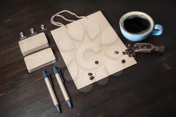 Blank vintage stationery set and coffee cup on wooden background. Responsive design mockup.