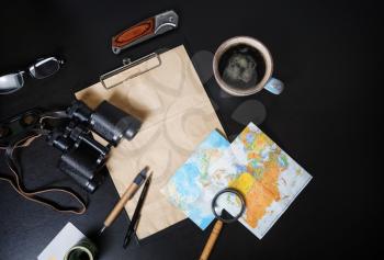 Accessories for travel. Traveler's outfit and vacation items on black table background. Flat lay.