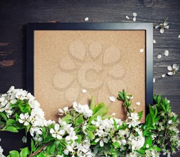 Blank photo frame with spring flowers on wooden background. Responsive design template. Top view. Flat lay.