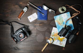 Traveler accessories and items for planning travel vacations on wooden background. Flat lay.