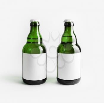 Two green beer bottles with blank labels. Responsive design mockup.