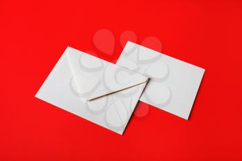 Blank paper envelopes on red paper background. Back and front. Mockup for placing your design.