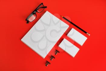 Photo of blank stationery set on red paper background. Corporate identity mockup. Responsive design template.