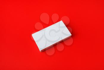 Blank business cards stack on red paper background. Corporate identity template.