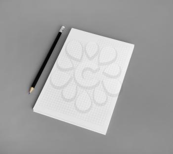Blank notepad and pencil on gray paper background. Branding identity mock up.