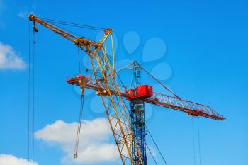 Two cranes against the blue sky background.