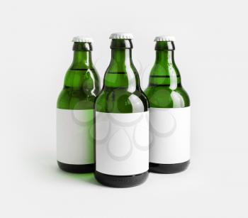 Three glass green beer bottles with with blank labels.