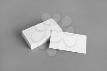 Blank white business cards on gray paper background. Mockup for branding identity. Template for graphic designers portfolios.