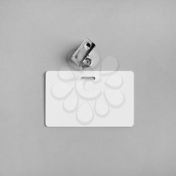 Blank white plastic badge on gray paper background. Responsive design template. Mock-up for your design. Flat lay.