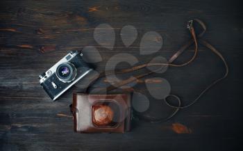 Old retro camera on vintage wooden background. Flat lay.