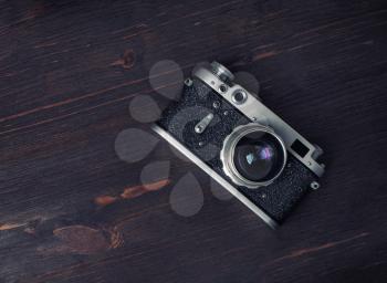 Old vintage camera on wood table background. Flat lay.
