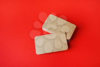 Blank kraft business cards on red paper background. Mockup for ID. Template for graphic designers portfolios.