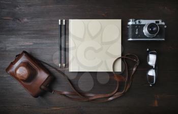 Retro camera with vintage items on wood table background. Flat lay.