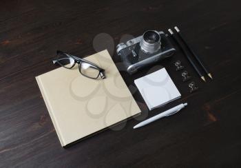 Blank stationery and vintage camera on wood table background.