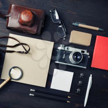 Travel concept with retro camera and blank vintage stationery on wooden background. Top view. Flat lay.