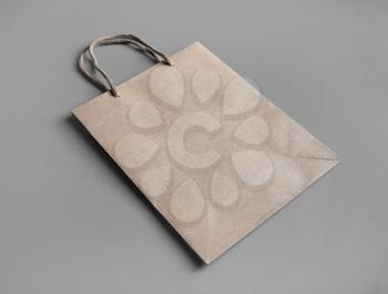 Disposable bag of kraft paper on gray paper background. Mockup of brown paper pack.