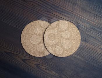 Photo of two blank cork beer coasters on wooden background. Responsive design mockup. Flat lay.