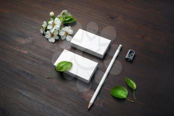 Branding stationery set. Blank business cards, pencil, sharpener and flowers on wooden background. Responsive design template.