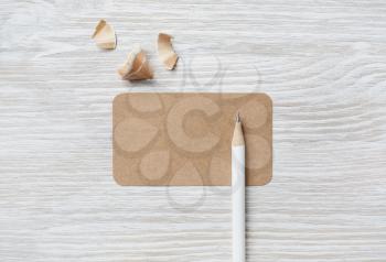 Blank business card and pencil. Blank stationery set on light wooden background. Flat lay.