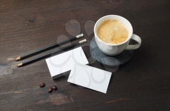 Blank business cards, pencils and coffee cup on wooden background. Template for ID.
