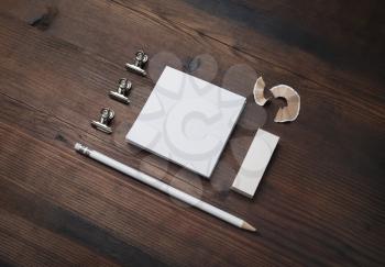 Photo of blank stationery set. Blank notes, pencil and eraser on wooden background.