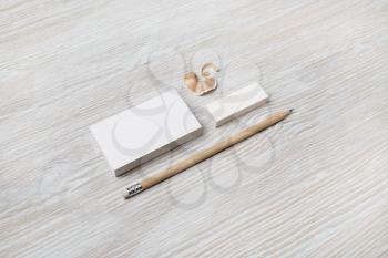 Blank business card, pencil and eraser on light wood table background. ID mockup. Responsive design template.