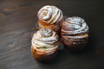 Three sweet buns on wood table background.