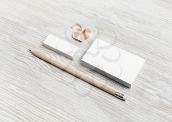 Brand ID mockup. Blank white business card, pencil and eraser on light wooden background.