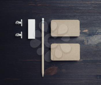 Blank stationery set. Kraft business cards, pencil and eraser on wooden background. Top view. Flat lay.