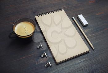 Blank kraft notebook, coffee cup, pencil and eraser on wooden background. Branding mock up.
