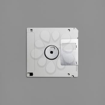 Floppy disk on gray paper background. Gray diskette. Top view. Flat lay.