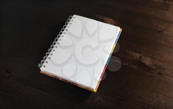 Blank notebook on wood table background. Responsive design mockup.