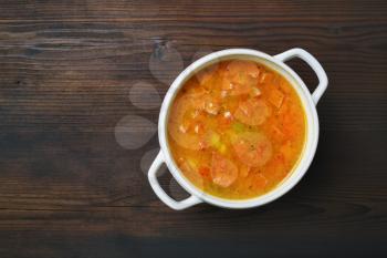 Bowl of soup on wood table background. Flat lay.