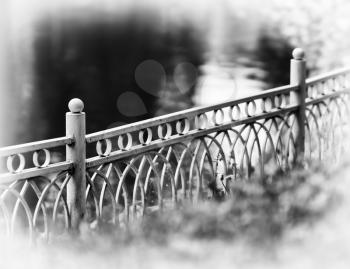 Horizontal diagonal black and white fence in park bokeh vignette background backdrop