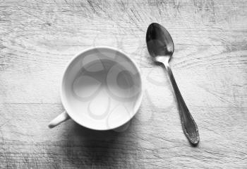Horizontal black and white empty cup with spoon bokeh background