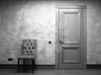 Strict arm-chair and door interior background