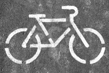Black and white bicycle symbol on textured asphalt background
