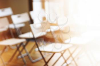 Classroom with empty chairs and warm bokeh background
