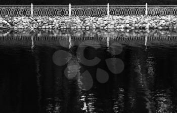 Horizontal black and white fence reflections on lake surface background backdrop