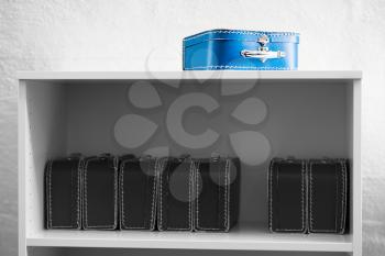 Blue toy case with black and white cases on the shelf background hd