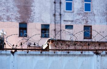 Prison wall with barbed wire city background hd