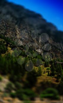 Vertical vivid summer toy mountain landscape bokeh background 