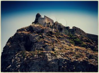 Horizontal vintage abandoned castle on the rock hill landscape postcard background