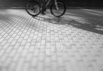 Bicycle rider silhouette on street pavement background