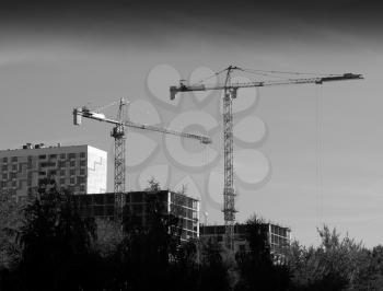 Construction cranes in Moscow background